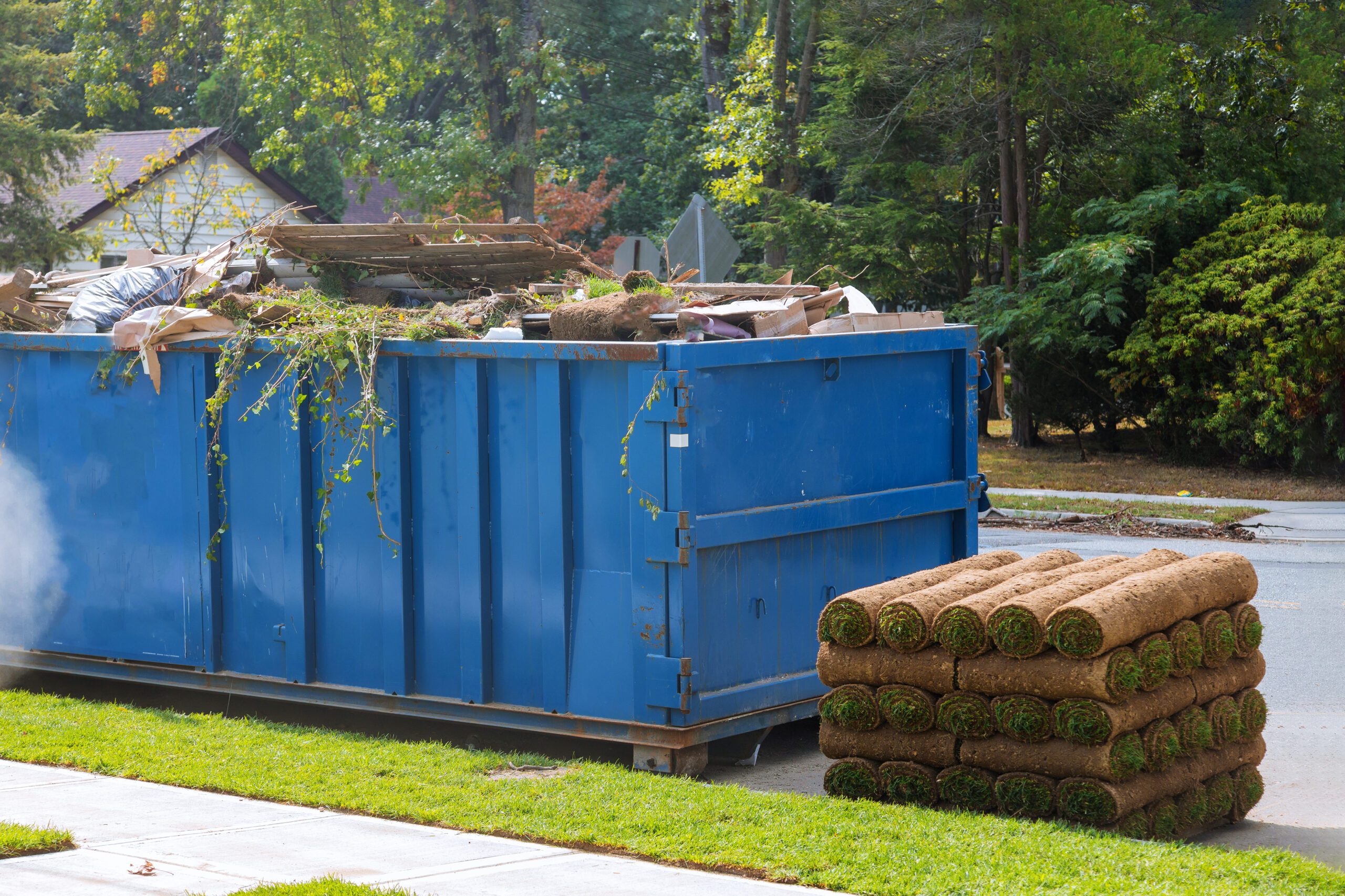 Hutchinson Dumpster Rental Roll off dumpster with lawn grass pallets sod and landscaping debris